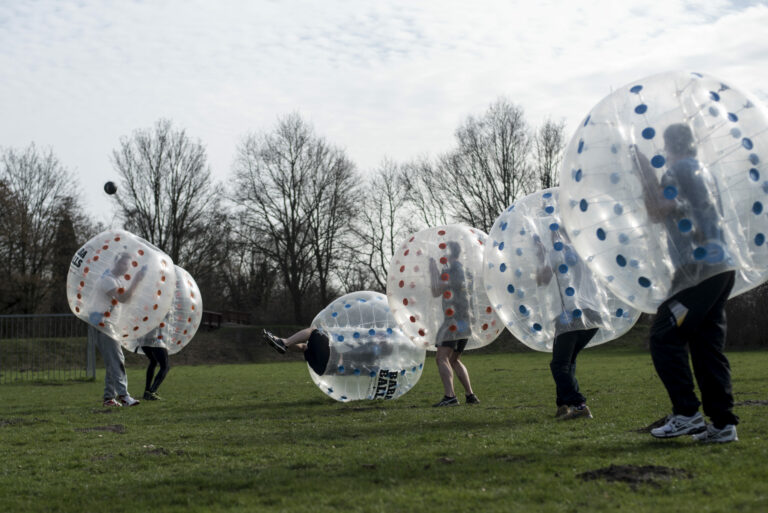 group playing a bubble football amsterdam experience outdoors