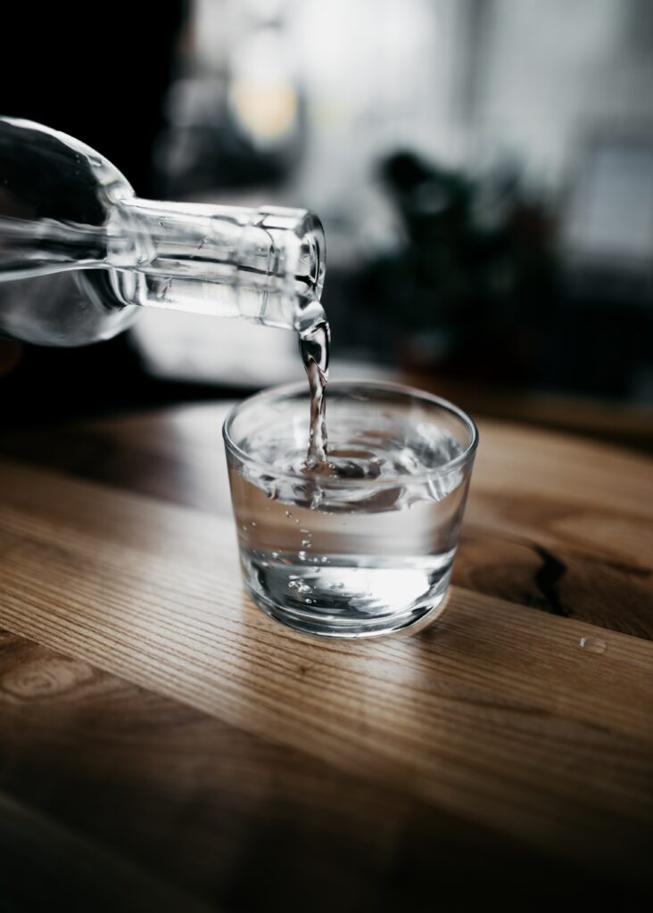 Glass of water being poured on a wooden table