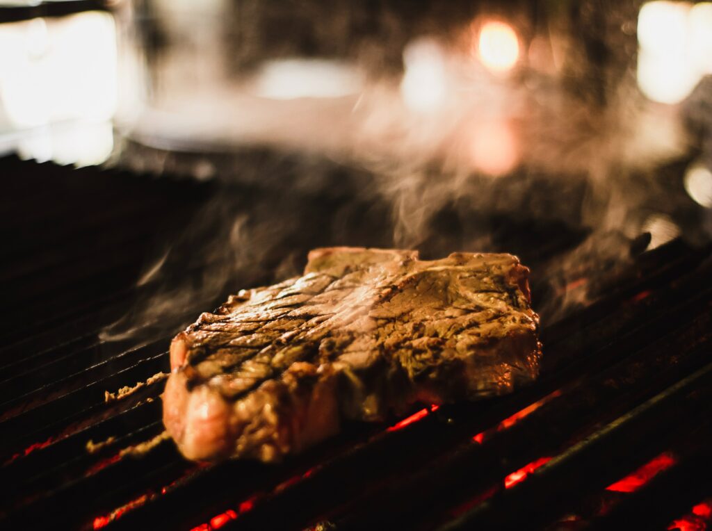 Steak being grilled on a fire