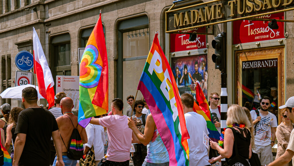 People with rainbow flags marching during the Gay Pride Amsterdam